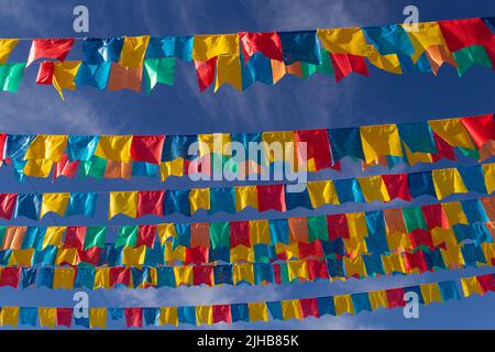 Goiania, Goiás, Brasile – 17 luglio 2022: Diverse linee di abbigliamento con bandiere di tessuto contro il cielo blu per la festa di giugno - tipico brasiliano 'Quadrilha' Foto Stock