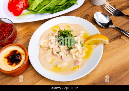piyaz stile Antalya o insalata di fagioli con tahini e fetta d'arancia su piatto di porcellana bianca Foto Stock