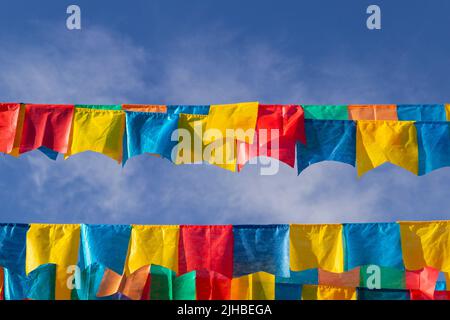 Goiania, Goiás, Brasile – 17 luglio 2022: Alcune linee di abbigliamento con pennanti di tessuto contro il cielo blu per il Partito di giugno - tipico brasiliano 'Quadrilha' Foto Stock