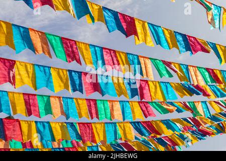 Goiania, Goiás, Brasile – 17 luglio 2022: Diverse linee di abbigliamento con bandiere di tessuto contro il cielo blu per la festa di giugno - tipico brasiliano 'Quadrilha' Foto Stock