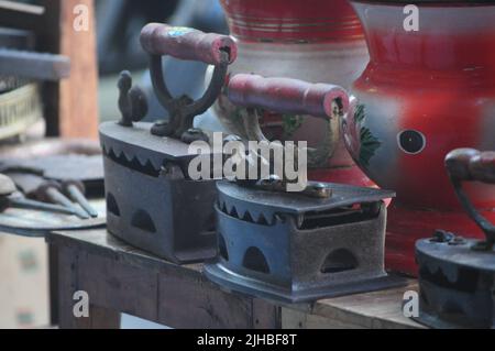 Antichi ferri a carbone di metallo e altri oggetti d'epoca sul mercato delle pulci. Oggetti da collezione Memorabilia Concept. Messa a fuoco selettiva Foto Stock