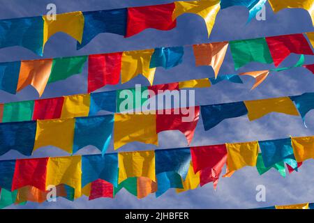 Goiania, Goiás, Brasile – 17 luglio 2022: Diverse linee di abbigliamento con bandiere di tessuto contro il cielo blu per la festa di giugno - tipico brasiliano 'Quadrilha' Foto Stock