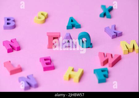 domande frequenti sulle lettere maiuscole colorate in legno su sfondo rosa Foto Stock