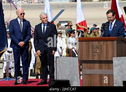 Tel Aviv, Israele. 13 luglio 2022. Il presidente israeliano Isaac Herzog, a destra, consegna le osservazioni che accolgono il presidente degli Stati Uniti Joe Biden, a sinistra, come primo ministro israeliano Yair Lapid, centro, guarda sopra durante le cerimonie di arrivo all'aeroporto ben Gurion, 13 luglio 2022 a Tel Aviv, Israele. Foto Stock