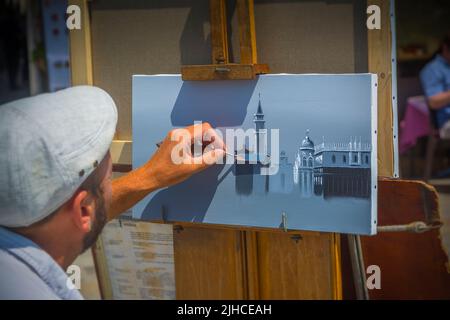 Artista di strada che lavora al suo dipinto vicino a Piazza San Marco a Venezia, Italia Foto Stock
