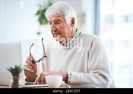 L'inferno va in pensione quando è il momento giusto. Un bel uomo d'affari anziano che lavora sul suo laptop a casa. Foto Stock