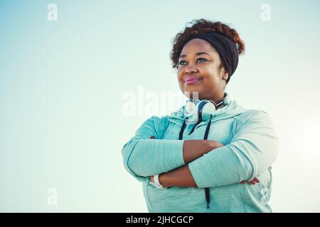 La forma fisica rende più forti la mente e il corpo. Una giovane donna sportiva in piedi all'aperto. Foto Stock