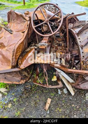 Un trattore abbandonato molto tempo fa e completamente coperto di ruggine. Foto Stock