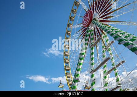 Vista dall'angolo basso della colorata ruota panoramica Bellevue, iconica ruota gigante del festival annuale di Rheinkirmes, contro il cielo blu. Foto Stock