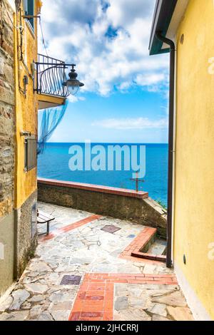 Una strada stretta con edifici gialli che si affacciano sul mare a Manarola, cinque Terre, Italia Foto Stock