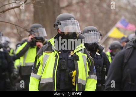 La polizia con le attrezzature per sommosse si riunisce fuori dal Campidoglio in quanto è stata sovraccarica dai sostenitori dell’allora presidente Donald Trump il 6 gennaio 2021. Foto Stock