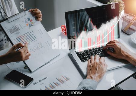 Il team aziendale che analizza grafici e grafici dei redditi, il team aziendale che lavora al computer con grafici olografici e statistiche del mercato azionario guadagna profitti, Foto Stock