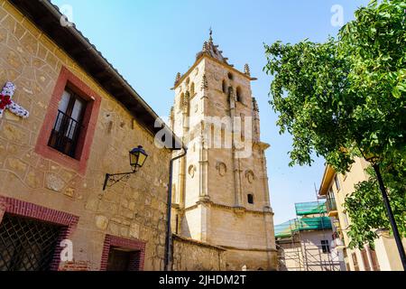 Torre gotica della chiesa di Torrelaguna, che si alza verso il cielo blu, Madrid. Foto Stock