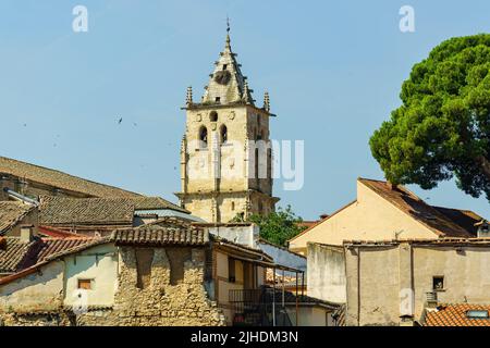 Torre della chiesa gotica di Torrelaguna sui tetti di vecchie case in rovina, Madrid. Foto Stock