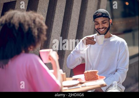 La giovane coppia si diverse insieme al caffè Foto Stock