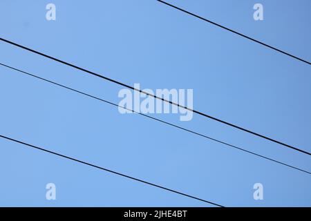 Linee di trasmissione della potenza contro il cielo blu profondo con spazio di copia Foto Stock
