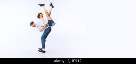 Ritratto di giovane coppia allegra, uomo e donna, in elegante abito retrò ballare isolato su sfondo bianco studio. Volantino Foto Stock