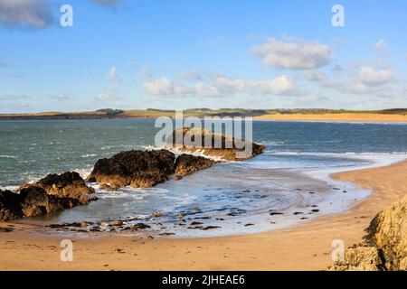 Piccola baia e vista sulla baia di Malltraeth e sulla spiaggia dalla riserva naturale nazionale di Ynys Llanddwyn Island, Newborough, Isle of Anglesey, North Wales, UK Foto Stock