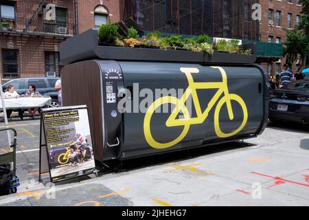 Una mini-cialde Oonee, un parcheggio custodito per 10 biciclette nella zona su 1 posto auto. Sulla 31st Avenue ad Astoria, Queens, New York City. Foto Stock