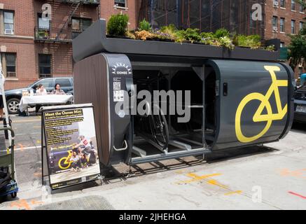 Una mini-cialde Oonee, un parcheggio custodito per 10 biciclette nella zona su 1 posto auto. Sulla 31st Avenue ad Astoria, Queens, New York City. Foto Stock