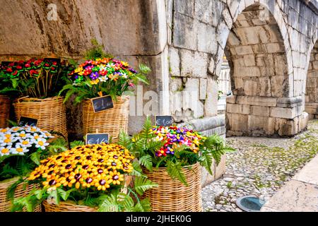 Bouquet di confetti in vendita sotto gli archi dell'Acquedotto Svevo, Sulmona, Italia Foto Stock