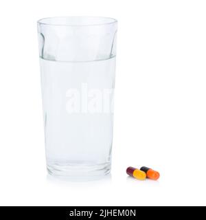 Vetro d'acqua. Capsula colore rosso giallo nero arancione. Prendere un medicinale. Isolato su sfondo bianco Foto Stock