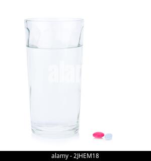 Vetro d'acqua. Vetro d'acqua. Pillola e compressa colore rosso e blu. Prendere un medicinale. Isolato su sfondo bianco Foto Stock