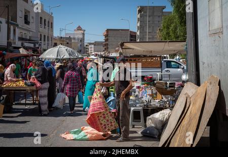 Un uomo vende abiti da tavola di plastica al Souk Domenica, un mercato settimanale a Sousse, Tunisia. Foto Stock