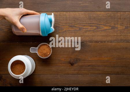 Flacone per agitatore sportivo in mani e proteine del siero di latte in vaso. Fitness e dieta palestra nutrizione Foto Stock