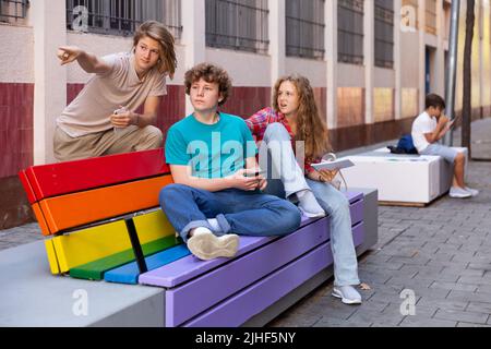 Guy punta la mano a qualcuno in compagnia di amici Foto Stock