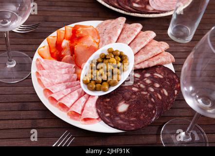 Piatto di antipasti con varie carni e olive Foto Stock