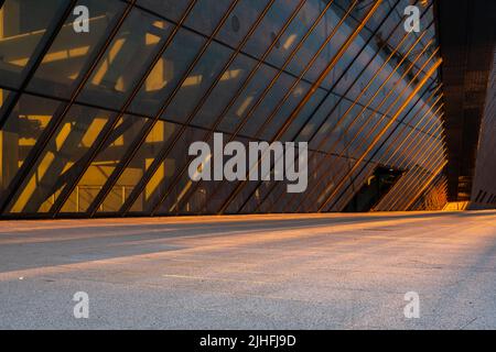 Backplate raffigurante un parcheggio sullo sfondo di un moderno edificio futuristico in acciaio e vetro Foto Stock