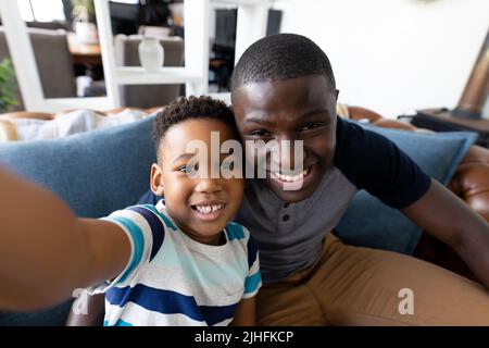 Immagine di padre e figlio afro-americani che prendono selfie Foto Stock