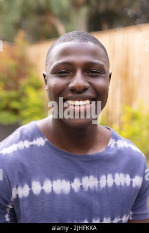 Ritratto verticale di un felice uomo afroamericano che guarda la macchina fotografica Foto Stock