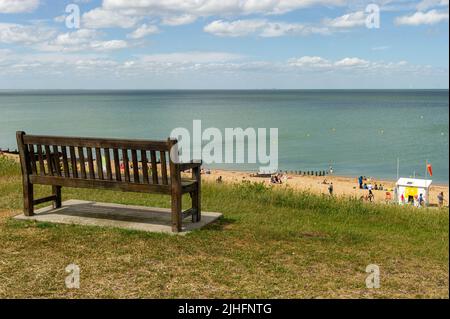 Panca di legno, con vista sulla spiaggia di Tankerton in una giornata di sole, Kent, Inghilterra Foto Stock