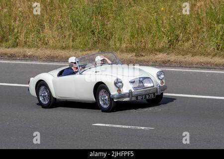 1961, 60s, Sessanta mg bianco A MGA 1600cc benzina British Sports Cabrio; guida sulla M6 autostrada, Manchester, Regno Unito Foto Stock
