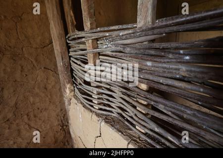 Partizione in vimini fatta di rametti in una vecchia casa. Foto Stock