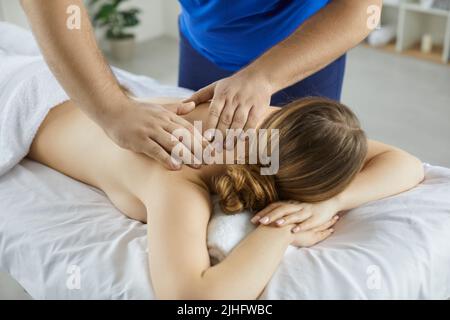 Massaggio massaggiante femmina del cliente lotta con il mal di schiena Foto Stock