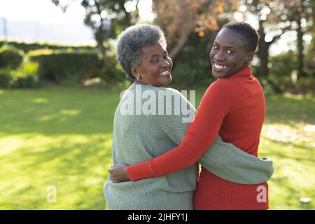 Immagine della felice madre afroamericana e della figlia adulta che posano in giardino Foto Stock