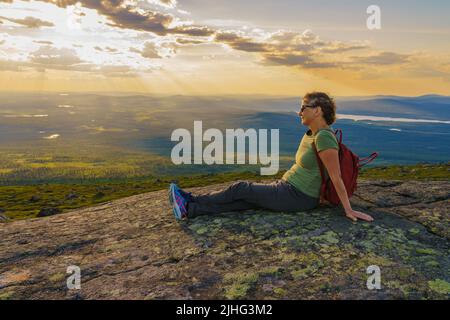 Donna seduta in montagna godendo la vista dal Monte Dundret su Laponia, contea di Gällivare, Lapponia svedese, Svezia