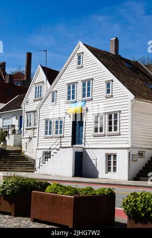 Tradizionale bandiera di volo bianca, casa di legno a sostegno dell'Ucraina, su Nedre Strandgate, Stavanger, Norvegia Foto Stock