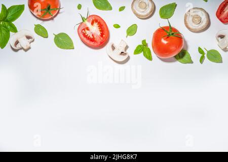 Funghi, pomodoro e basilico isolati su bianco. Motivo a superficie piana su sfondo bianco, vista dall'alto Foto Stock