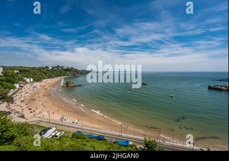 Tenby, Galles - Maggio 2021 : persone che godono di sole giorno caldo sulla storica spiaggia e costa della città di Tenby, Carmarthen Bay, Pembrokeshire Foto Stock