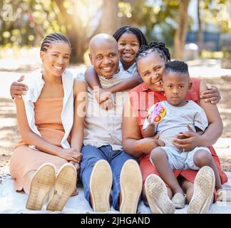 Ritratto Happy famiglia afroamericana di cinque trascorrere del tempo di qualità insieme nel parco durante l'estate. Nonni, madre e bambini che si legano Foto Stock