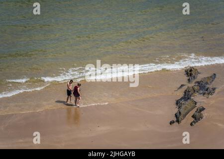 Tenby, Galles - Maggio 2021 : persone che godono di sole caldo giorno sulla spiaggia e la costa della città di Tenby, Carmarthen Bay, Pembrokeshire Foto Stock