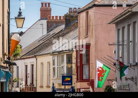 Tenby, Galles - Maggio 2021 : Bandiera gallese tra case colorate in una bella cittadina di Tenby, Pembrokeshire, Carmarthen Bay, Gran Bretagna Foto Stock