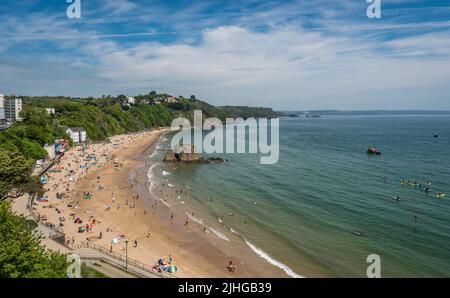 Tenby, Galles - Maggio 2021 : persone che godono di sole giorno caldo sulla storica spiaggia e costa della città di Tenby, Carmarthen Bay, Pembrokeshire Foto Stock