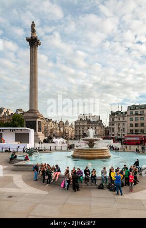 Londra, Inghilterra, Regno Unito - 26 settembre 2013: Persone che riposano accanto alla fontana sulla Trafalgar Square nel centro di Londra. Foto Stock