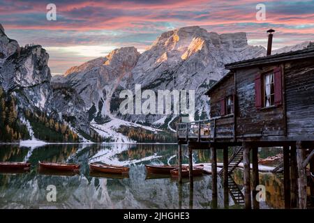 Paesaggio pittoresco con il famoso lago di Braies in autunno Dolomiti montagne. Barche in legno e molo nelle acque limpide del Lago di Braies, Alpi dolomitiche, Italia. Vetta del monte Seekofel sullo sfondo Foto Stock