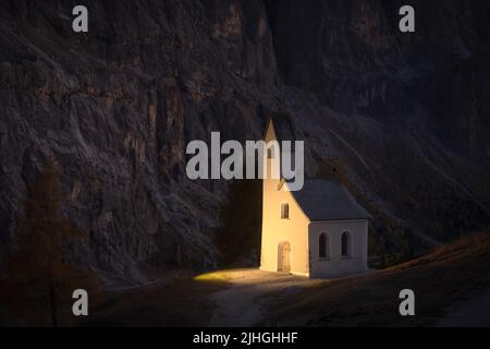 Incredibile vista sulla piccola cappella iIlluminated - Kadelle Ciapela sul Passo Gardena, Dolomiti Italiane. Alpi dolomitiche, Italia. Fotografia di paesaggio Foto Stock